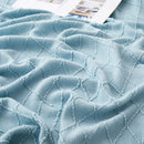 plaid tricoté jacquard à pompons motif carreaux salon