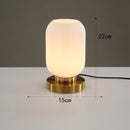 Lampe à poser cylindrique en verre coloré et base dorée Quinn